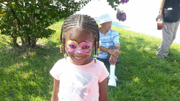 Pretty girl with a butterfly face painting at a party.